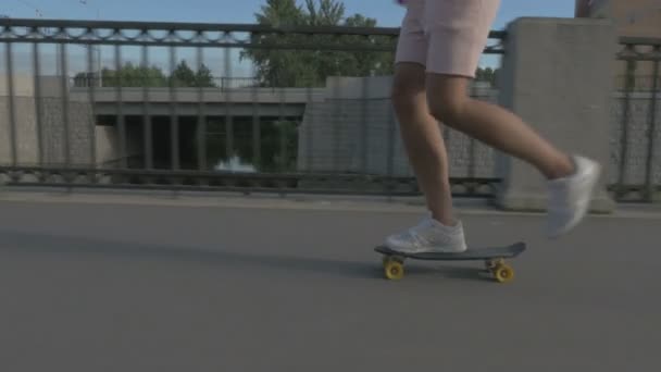 Ноги скейтбордиста на скейтборде по дороге в город — стоковое видео