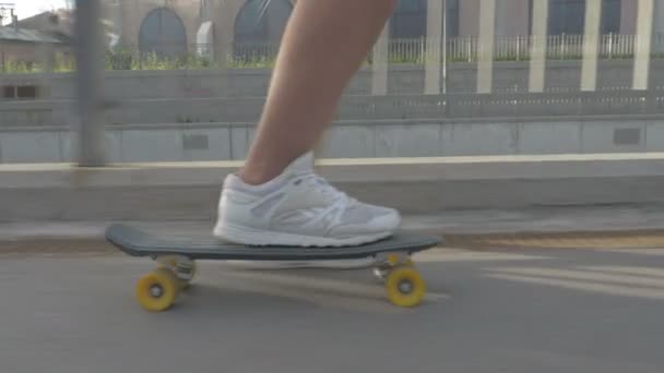 Legs of skateboarder to ride a skateboard on the road in the city — ストック動画