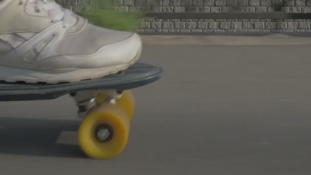 Legs of skateboarder to ride a skateboard on the road in the city — Stock video