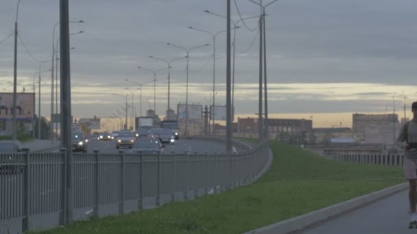 Młody facet w mieście na deskorolce z tabletem w parze w lecie — Wideo stockowe