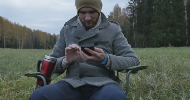 Ung glad Man pratar i mobiltelefon i parken — Stockvideo