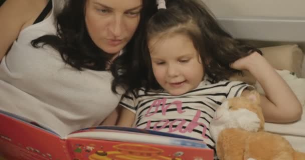 Matka četla její dceru knihu před postelí. — Stock video