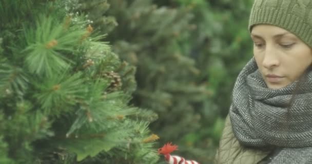 Véspera de Ano Novo, menina na loja escolhe decorações de Natal, brinquedos, bolas, cones . — Vídeo de Stock