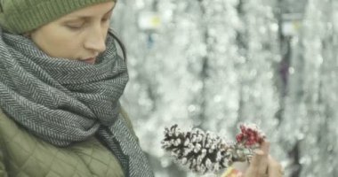 Yeni yıl arifesinde, kız vasıl belgili tanımlık stok seçer Noel süsleri, oyuncaklar, topları, koniler.