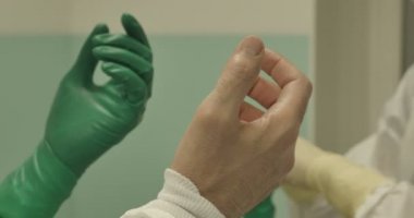 Takım koruyucu giysiler sterilize ekipmanı kullanarak ameliyat çalışma cerrahi eldiven eller yukarı kapatın