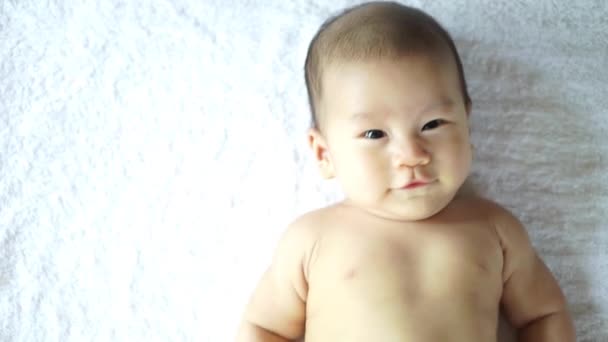 Asiatisches Baby liegt auf einer Decke — Stockvideo