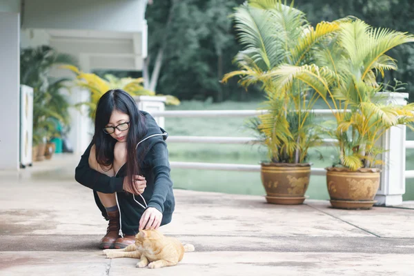 Азиатская девушка играет с котом — стоковое фото