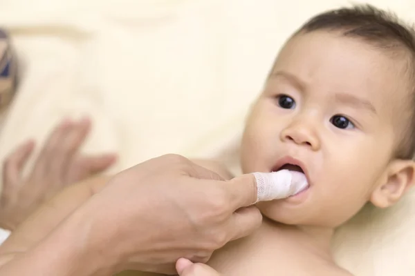 Mãe limpa a boca do bebê — Fotografia de Stock