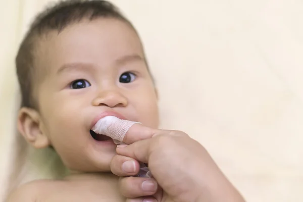 Matka czyści usta dziecka — Zdjęcie stockowe