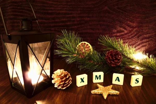 Xmas woord met zaklamp kaars, ster, pine tak en oranje — Stockfoto