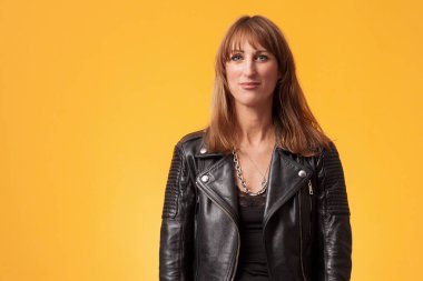 Sarı bir fonun önünde siyah deri ceket giyen güzel bir kadının portresi.