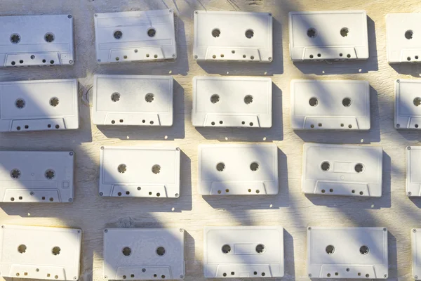 Audio cassettes are covered with white acrylic paint. Excellent retro. Creative decor.