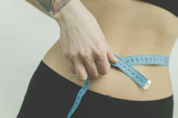 Measuring womans waist in the gym — Stock Photo, Image