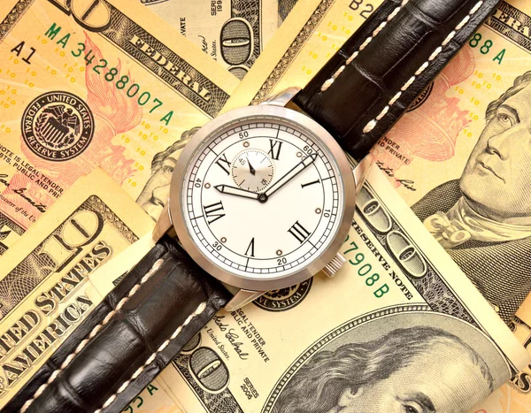 Банкноты долларов и часы — стоковое фото
