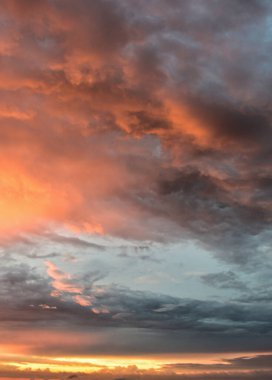 Büyülü günbatımı renkleri bulutlar arasında yayılıyor, biraz kasvetli öğleden sonra gökyüzünü yumuşatıyor ve doğal ahenkle dolu sakin bir atmosfer yaratıyor..