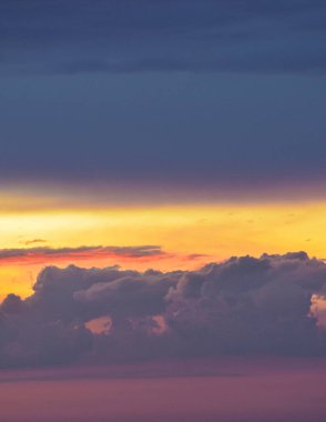 Yumuşak bulutlar parıldayan günbatımı renklerini emer, sıcak tonlarla dolu huzurlu bir öğleden sonra anını şekillendirir ve doğal güzellikleri yatıştırır.