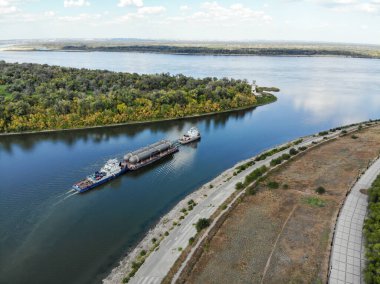 Volga nehri üzerinde nehir yoluyla kargo taşımacılığı. - Evet. Petrol rafinerisi için malzeme taşıyan bir mavnayı çekiyorlar. Nehir filosu.