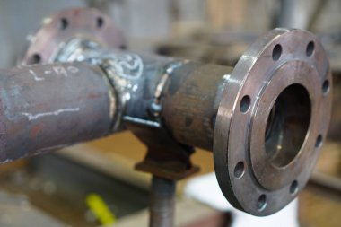 Yeni flanj ve boru hattı DN 100, bir petrol rafinerisindeki teknolojik bir kompleks için elektrik yayı kaynak ve müteakip ısı tedavisi       