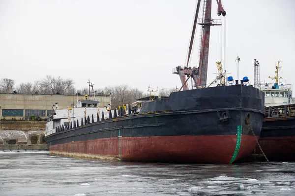 Old rusty motor ship. Wintering ships on a frozen river in their port. Volgograd. Russia.