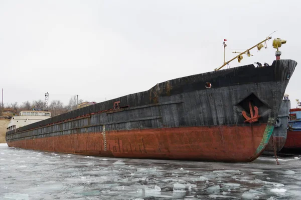 Old rusty motor ship. Wintering ships on a frozen river in their port. Volgograd. Russia