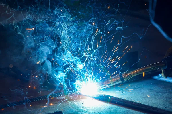 Metal kaynaklama. Petrol rafinerisindeki bir atölyede yarı otomatik çubuk ve metal yapılar kaynak.     