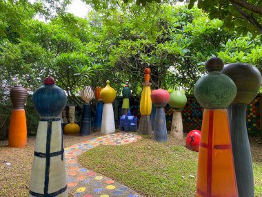 Serin bir bahçe yolu taştan bir köprü, yeşil çimenler ve güzel bir açık hava parkındaki ağaçların arasına yerleştirilmiş mimari elementlerle dolu bereketli doğa boyunca esiyor.