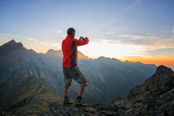 Wanderer fotografiert den Sonnenuntergang mit seinem Smartphone — Stockfoto