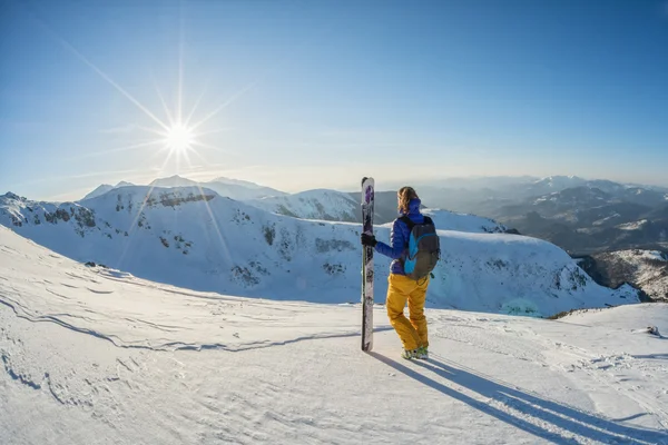 Esquiador mirando la puesta de sol desde la cima de la montaña — Foto de Stock