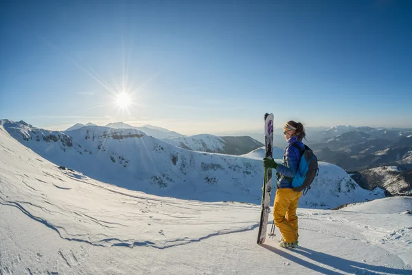 Sciatore che guarda il tramonto dalla cima della montagna — Foto Stock