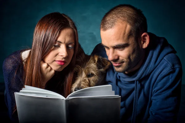 Çift ve bir kitap okuma onların köpek — Stok fotoğraf