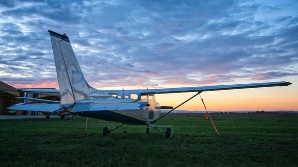 Pequeno avião estacionado na grama — Fotografia de Stock