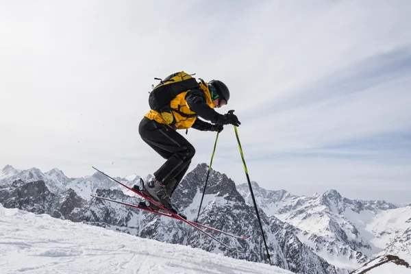Skifahrer hebt als Zeichen des Erfolgs nach Erreichen des Gipfels seine Ausrüstung in die Luft — Stockfoto