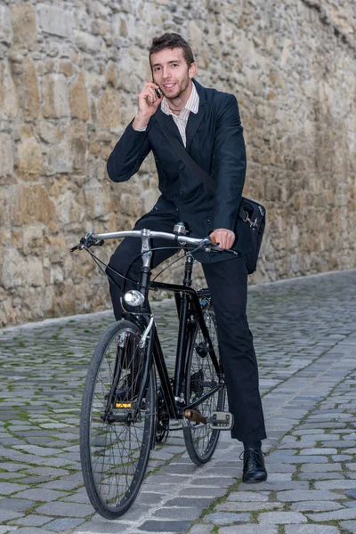 Unga casual affärsman på sin cykel — Stockfoto