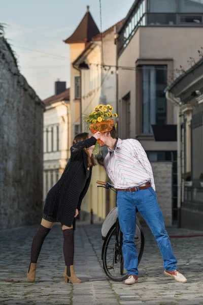 年轻的女人和男人亲吻背后一束鲜花 — 图库照片