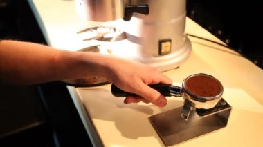 Barmen görünümünü çekilmiş kahve sıkıştırır