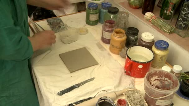 Original artist paints self-made ceramic tile — Stock Video