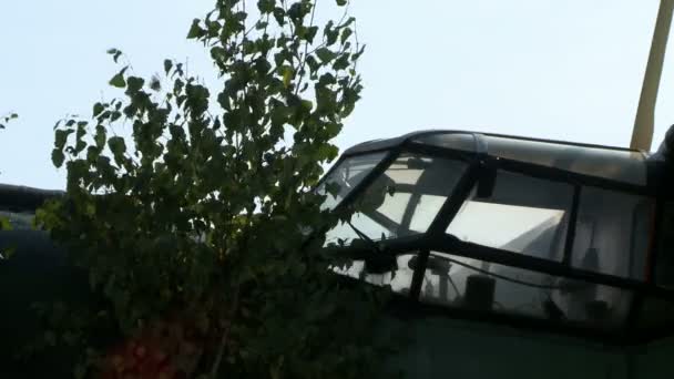 Кабина заброшенного самолета и дерева рядом с ним — стоковое видео