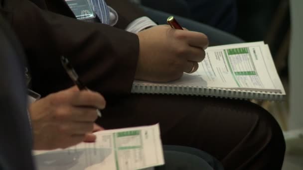 Företagskonferens. Män gör anteckningar i handboken — Stockvideo