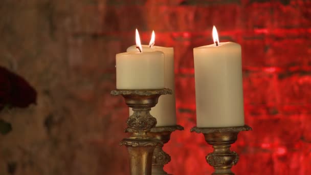 Зажженные свечи в золотых подсвечниках, крупным планом — стоковое видео