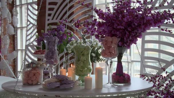 Mesa de postres decorada con flores y velas — Vídeo de stock