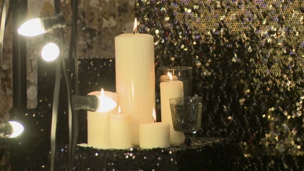 Brennende Kerzen auf Vorhängen mit Pailletten — Stockvideo