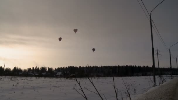 Karla kaplı alan üzerinde uçan sıcak hava balonları — Stok video