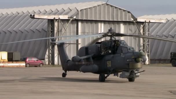 Military helicopter on background of hangars — Stock Video