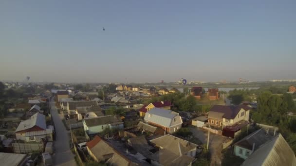 Varmluftsballonger flyga över stuga bosättningen — Stockvideo