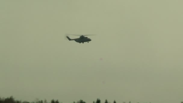 Military helicopter flies in cloudy sky — Stock Video