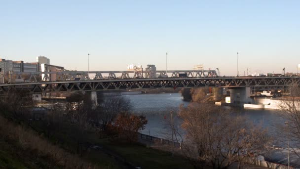 Tráfico en el puente en la vista de la ciudad desde la orilla del río Video de stock libre de derechos