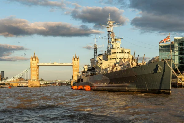 HMS Belfast kruvazörü ve Tower Köprüsü Thames 'de gün batımında, Londra, İngiltere' de görüldü.