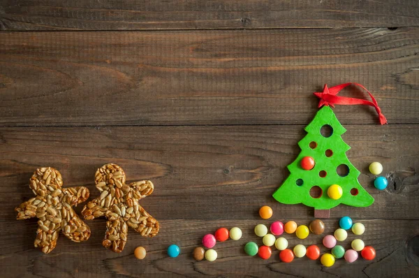 Weihnachten Hintergrund mit einem Spielzeugbaum und Schokoladendragee in einer farbigen Glasur — Stockfoto