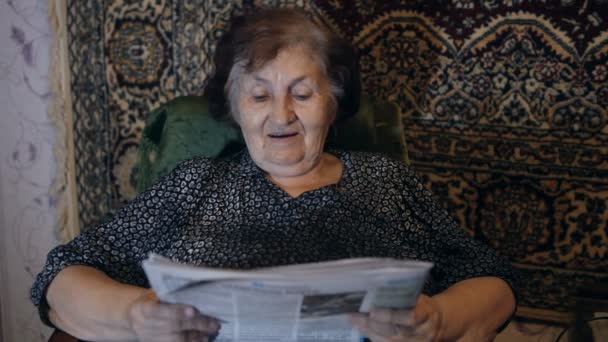 Mulher velha lendo o jornal em casa — Vídeo de Stock