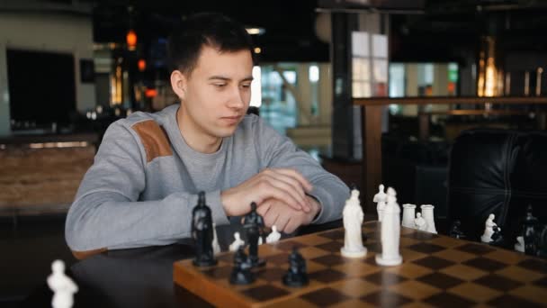 Young man playing chess in the restaurant — Stock Video